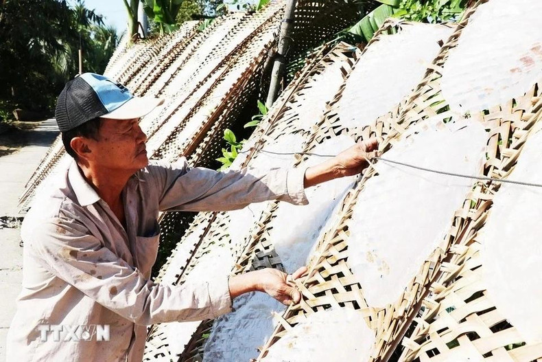 Huynh Van Cuoi de la aldea de Hau Thuan, comuna de Hau Thanh, revisa el producto terminado.