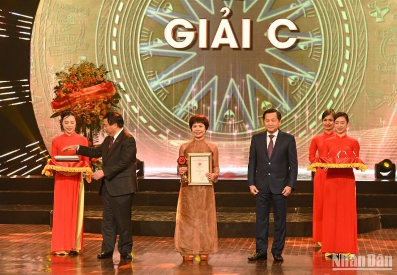 El director de la Academia Nacional de Política Ho Chi Minh, Nguyen Xuan Thang, y el viceprimer ministro, Le Minh Khai, entregan los Premios C a la autora Tieu Phuong del periódico Nan Dan. El director de la Academia Nacional de Política Ho Chi Minh, Nguyen Xuan Thang, y el viceprimer ministro, Le Minh Khai, entregan los Premios C a la autora Tieu Phuong del periódico Nan Dan.