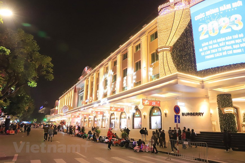 El centro comercial Trang Tien Plaza brilla con luces doradas y los paneles.