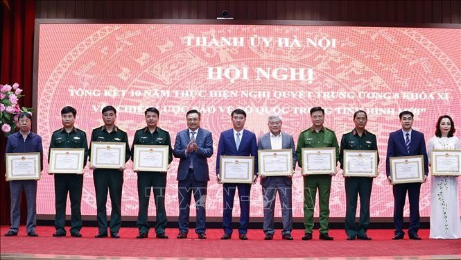 Tran Sy Thanh, vicesecretario del Comité partidista y presidente del Comité Popular de Hanói, otorga certificados de mérito a los colectivos.