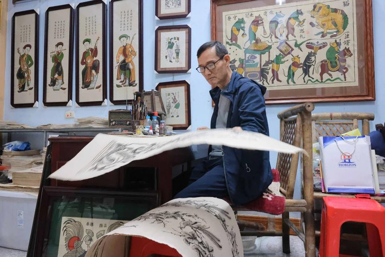 El artista Nguyen Huu Qua todavía trabaja todos los días con pinceles y papel Do para preservar las pinturas populares tradicionales. El artista Nguyen Huu Qua todavía trabaja todos los días con pinceles y papel Do para preservar las pinturas populares tradicionales.