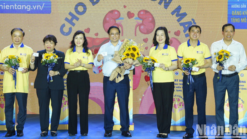 La presidenta de la Asociación Vietnamita de Donación de Órganos y Tejidos entrega a Minh Chinh la tarjeta de registro de donación de órganos y tejidos.