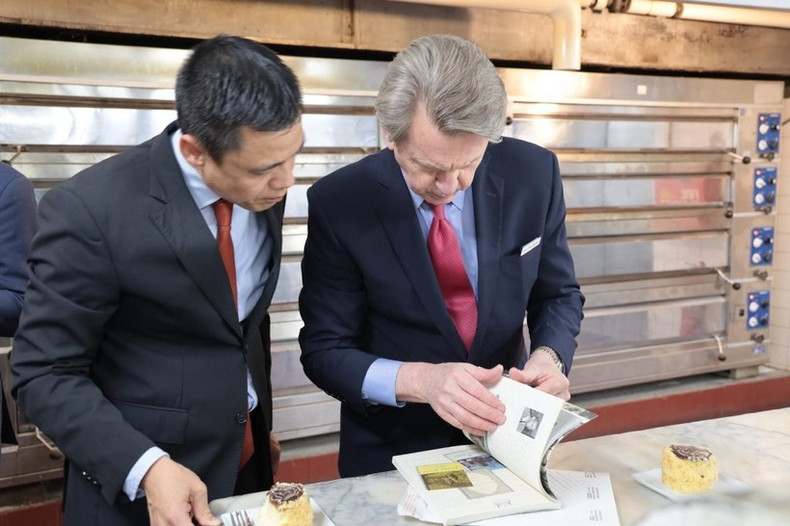 El embajador Dang Hoang Giang y el director general del hotel Omni Parker House, John Murtha, intercambian sobre los contenidos relacionados con el Presidente Ho Chi Minh en el libro sobre la historia del hotel.