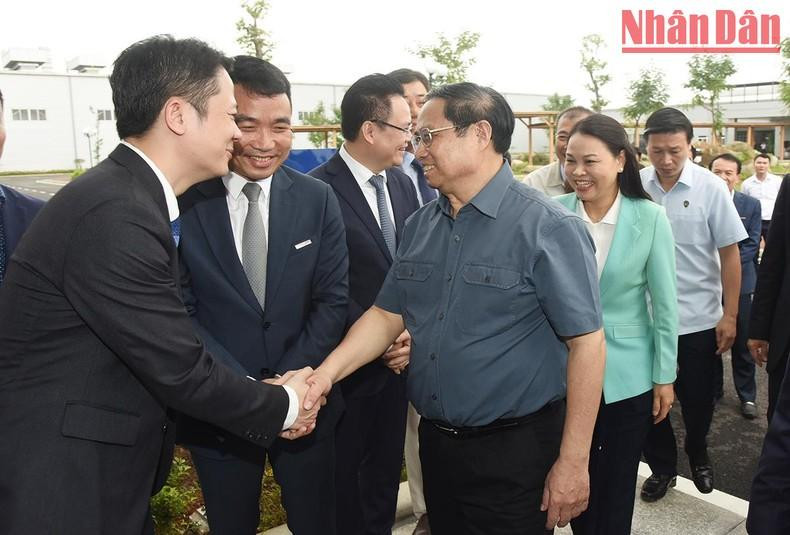 Trabajadores del Grupo Thanh Cong dan la bienvenida al primer ministro Pham Minh Chinh.