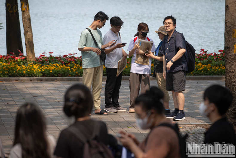 Los estudiantes explican a los turistas extranjeros sobre el evento especial del periódico Nhan Dan. Los estudiantes explican a los turistas extranjeros sobre el evento especial del periódico Nhan Dan.