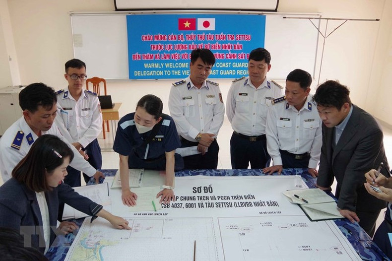 Los oficiales del barco patrullero Settsu, de la Guardia Costera de Japón, y del Alto Mando de la Región 2 de la Guardia Costera de Vietnam, debaten los planes del ejercicio conjunto de búsqueda y rescate marítimo.
