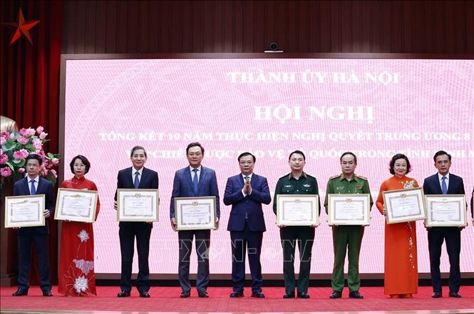 Dinh Tien Dung, secretario del Comité del Partido Comunista de Vietnam en Hanói, otorga certificados de mérito a los colectivos con logros destacados en la implementación de la Resolución.