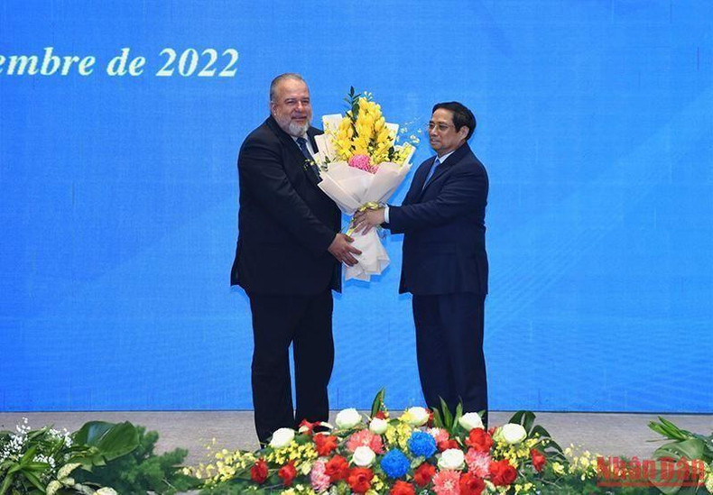 Minh Chinh entrega flores para felicitar a Manuel Marrero Cruz.