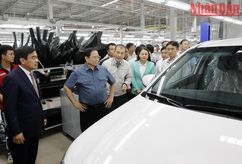 El primer ministro Pham Minh Chinh contempla un modelo de coche.