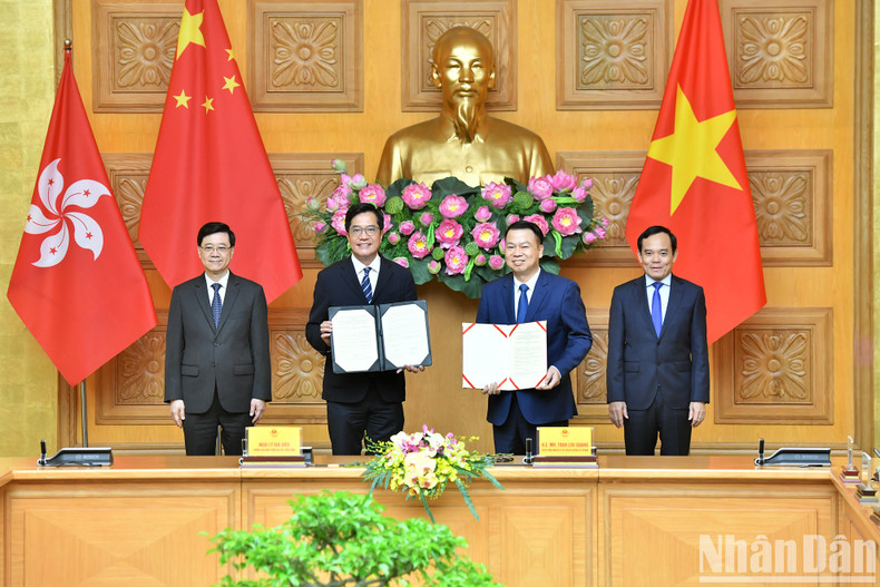 Luu Quang y John Lee Ka-chiu presencian la firma de documentos de cooperación bilateral.