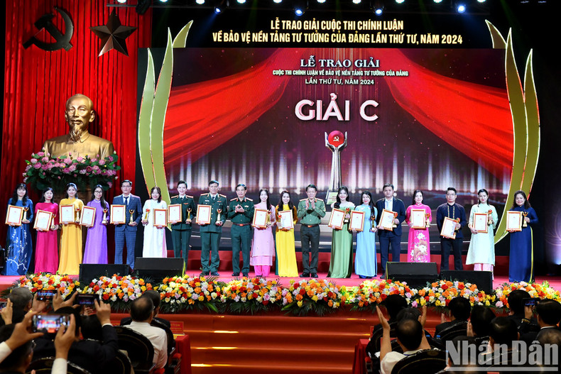 El general Phan Van Giang, miembro del Buró Político, ministro de Defensa, y el general Luong Tam Quang, miembro del Buró Político, ministro de Seguridad Pública, otorgan el Premio C a los autores y grupos de autores.