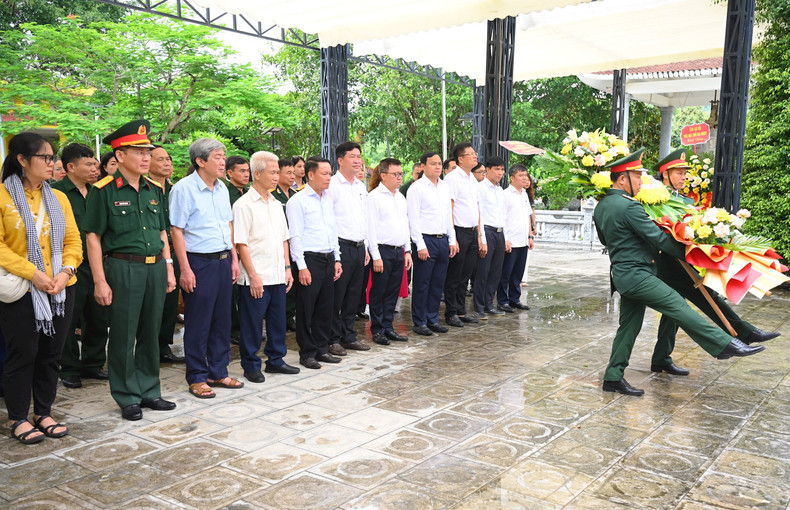 Los delegados ofrecen flores a los mártires heroicos en el cementerio.