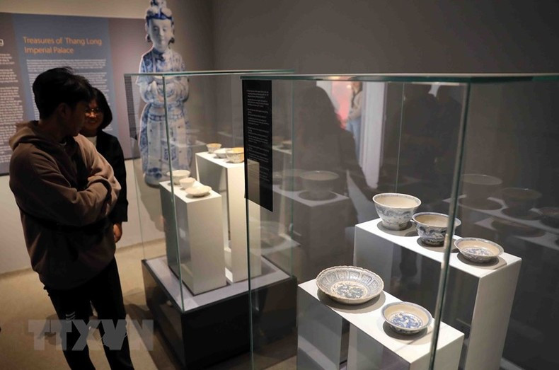 Los visitantes observan la colección de cuencos y platos. Los visitantes observan la colección de cuencos y platos.