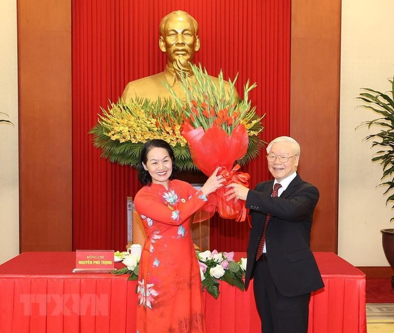 La presidenta de la Cruz Roja de Vietnam, Bui Thi Hoa entrega flores al secretario general del PCV, Nguyen Phu Trong.