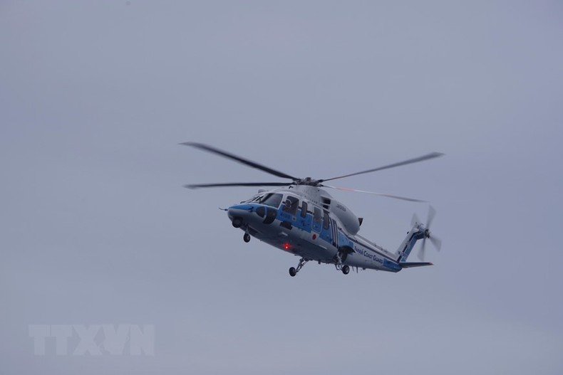 El helicóptero del barco patrullero Settsu también participa en la maniobra.
