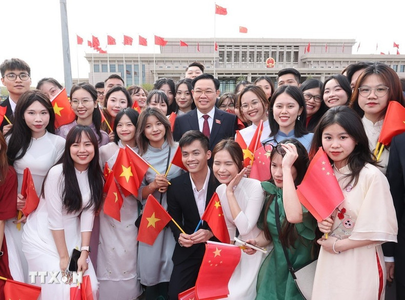 Dinh Hue con la comunidad vietnamita en China en el aeropuerto internacional de Pekín.