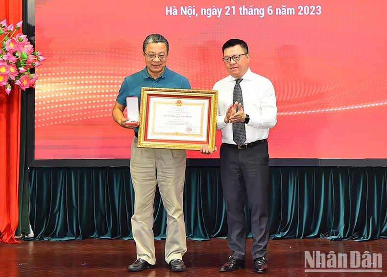 Quoc Minh otorga la Orden Laboral de segunda clase del Presidente de Estado a Tran Viet Cuong, ex miembro del consejo editorial y ex jefe de administración de Nhan Dan.