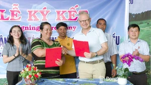 Thi Khui, directora de la Cooperativa Agrícola de Anacardo Orgánico Trang Co Bu Lach, firma un acuerdo de cooperación un representante de la empresa Intersnack Vietnam. (Foto: Periódico Dong Nai)