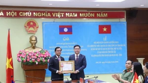 Por autorización del Primer Ministro del Gobierno laosiano, el compañero Leklai Sivilay otorga la Orden de Trabajo de primera clase del Gobierno laosiano a Nguyen Dinh Trung, secretario del Comité del Partido Comunista de Vietnam en Dak Lak. (Fotografía: Nhan Dan)