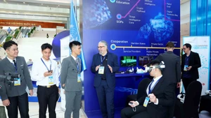 Delegados visitan el espacio de exhibición de tecnología de las Naciones Unidas durante la ceremonia de firma de la Convención de Hanói. (Foto: VNA)