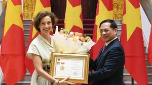 El vice primer ministro y titular de Relaciones Exteriores de Vietnam, Bui Thanh Son, entrega a la directora general de la Unesco, Audrey Azoulay, la insignia “Por la causa de la diplomacia vietnamita”. (Fotografía: VGP)