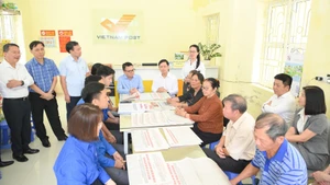 La delegación de Nhan Dan y la Corporación de Correos de Vietnam se reúne con pobladores de la comuna de Hong Nam, en la provincia de Hung Yen.