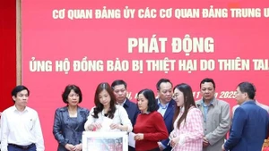 Funcionarios y empleados del Comité partidista en órganos centrales del Partido realizan donaciones para ayudar a las personas afectadas por tormentas e inundaciones. (Foto: VNA)