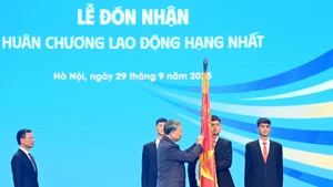 En nombre del Partido y del Estado, el secretario general del Partido Comunista de Vietnam, To Lam, otorga la Orden de Trabajo de Primera Clase al Ministerio de Ciencia y Tecnología por sus logros excepcionales. (Foto: Nhan Dan)