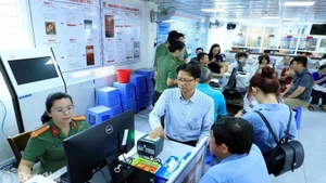 Funcionarios del Departamento de Inmigración enseñan a los extranjeros el proceso de otorgamiento de cuentas de identificación electrónica de nivel 2. (Fotografía: sggp.org.vn)