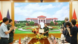 El teniente general Hoang Xuan Chien, viceministro de Defensa de Vietnam, entrega un certificado de reconocimiento a Aler Grubbs por sus destacadas contribuciones a la remediación del Agente Naranja/dioxina en Vietnam. (Fotografía: VNA)