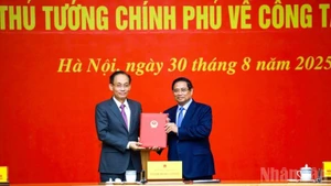 El primer ministro Pham Minh Chinh entrega la decisión de nombramiento al miembro del Secretariado del Comité Central del Partido Comunista de Vietnam y jefe de su Oficina, Le Hoai Trung. (Foto: VNA)