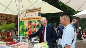Un cliente checo conversa con el delegado de una empresa vietnamita de viaje en el evento. (Fotografía: VNA)