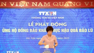 La directora general de la VNA, Vu Viet Trang, ofrece una donación para apoyar a las personas afectadas a superar las consecuencias de las tormentas e inundaciones. (Foto: VNA) 