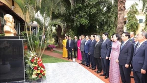 El presidente Luong Cuong, su esposa y la delegación vietnamita de alto rango que les acompañan depositan flores ante el busto del Presidente Ho Chi Minh en la Embajada de Vietnam en Luanda. (Foto: VNA)