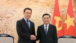 El integrante del Buró Político y miembro permanente del Secretariado del Comité Central del Partido Comunista de Vietnam, Tran Cam Tu (derecha), recibe al jefe interino de la Comisión de Asuntos Exteriores del Comité Central del Partido Popular Revolucionario de Laos, Bounleua Phandanouvong. (Fotografía: VNA)