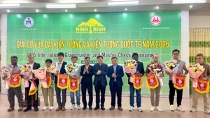 Un representante del torneo entrega estandartes de recuerdo a las delegaciones participantes. (Foto: Nhan Dan)