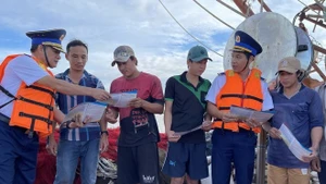 Las fuerzas encargadas de hacer cumplir la ley marítima difunden información sobre la pesca INDNR entre los pescadores. (Foto: VNA)