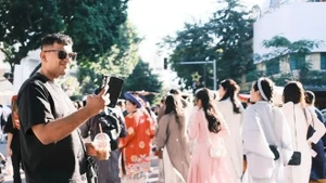 Turistas capturan momentos durante el desfile del Festival de Trajes Vietnamitas en Hanói el 15 de noviembre. (Foto: sggp.org.vn)