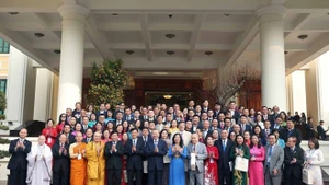 El secretario general del Partido Comunista de Vietnam, To Lam, se toma una foto con destacados residentes connacionales en el extranjero que asisten al programa "Primavera en la Patria" en 2025. (Fotografía: VNA)