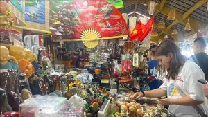 Turistas extranjeros eligen productos artesanales en Ciudad Ho Chi Minh para comprar como recuerdo. (Foto: VNA)