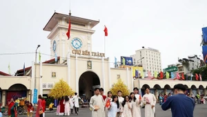 Turistas posan al frente del mercado de Ben Thanh, un emblema de Ciudad Ho Chi Minh. (Foto: VNA)