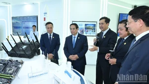 El primer ministro Pham Minh Chinh visita la sala memorial y de productos tecnológicos del Grupo VNPT. (Foto: Nhan Dan)
