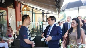 El primer ministro Pham Minh Chinh y su esposa visitan a empresarios vietnamitas en el casco antiguo de Niza. (Fotografía: VNA)