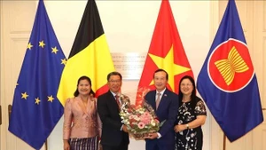 El embajador de Laos en Bélgica, Kingphokeo Phommahaxay (izquierda), entrega flores al embajador de Vietnam en el país europeo, Nguyen Van Thao. (Foto: VNA)