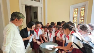 Alumnos habaneros curiosos por un prototipo del Tambor de bronce, símbolo de la cultura vietnamita. (Fotografía: Embajada de Vietnam en Cuba)