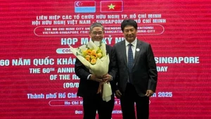 El presidente de la VSFA, Lam Dung Tien, entrega flores al cónsul general de Singapur en Ciudad Ho Chi Minh, Pang Te Cheng, en la reunión. (Foto: sggp.org.vn)