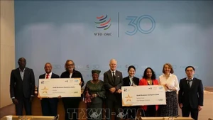 El ministro consejero Pham Quang Huy (primero a la derecha) y el comité organizador del Concurso Campeones de las Pequeñas Empresas 2025. (Fotografía: VNA)