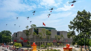 Una escuadrilla de 10 helicópteros, portando la bandera del Partido Comunista de Vietnam y la bandera nacional, sobrevuela la plaza de Ba Dinh. (Foto: Giang Huy)