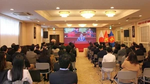 Vietnamitas residentes en Tokio siguen la inauguración del XIV Congreso Nacional del Partido.