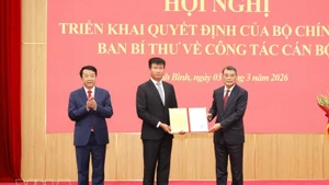 Le Minh Hung, miembro del Buró Político, secretario del Comité Central del Partido y jefe de su Comisión de Organización, entrega la decisión a Tran Huy Tuan. (Foto: VNA)